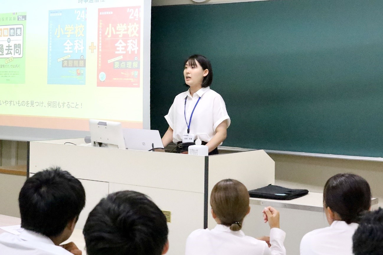 小学校ブースで説明する本学卒業生の太田百香さん