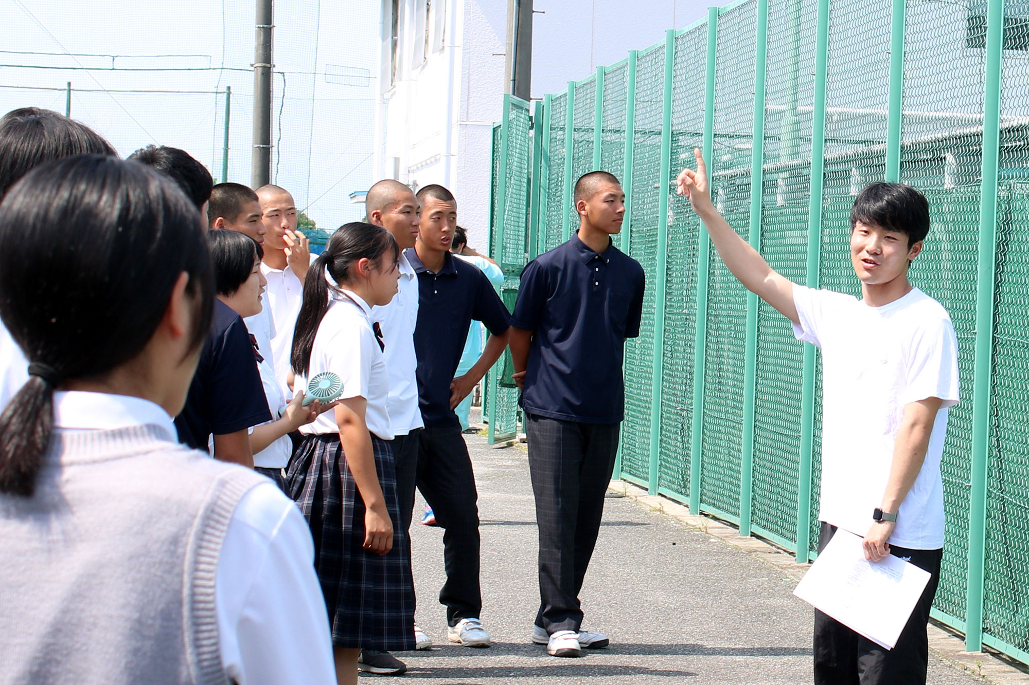 桜宮高校OBで体育学部4年の佐藤耕世さんから施設の説明を受ける高校生